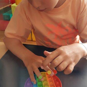 Kind drückt Pop-It Spielzeug mit beiden Händen